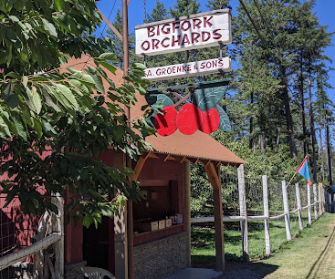 Bigfork Orchards fruit stand beneath the orchard sign
